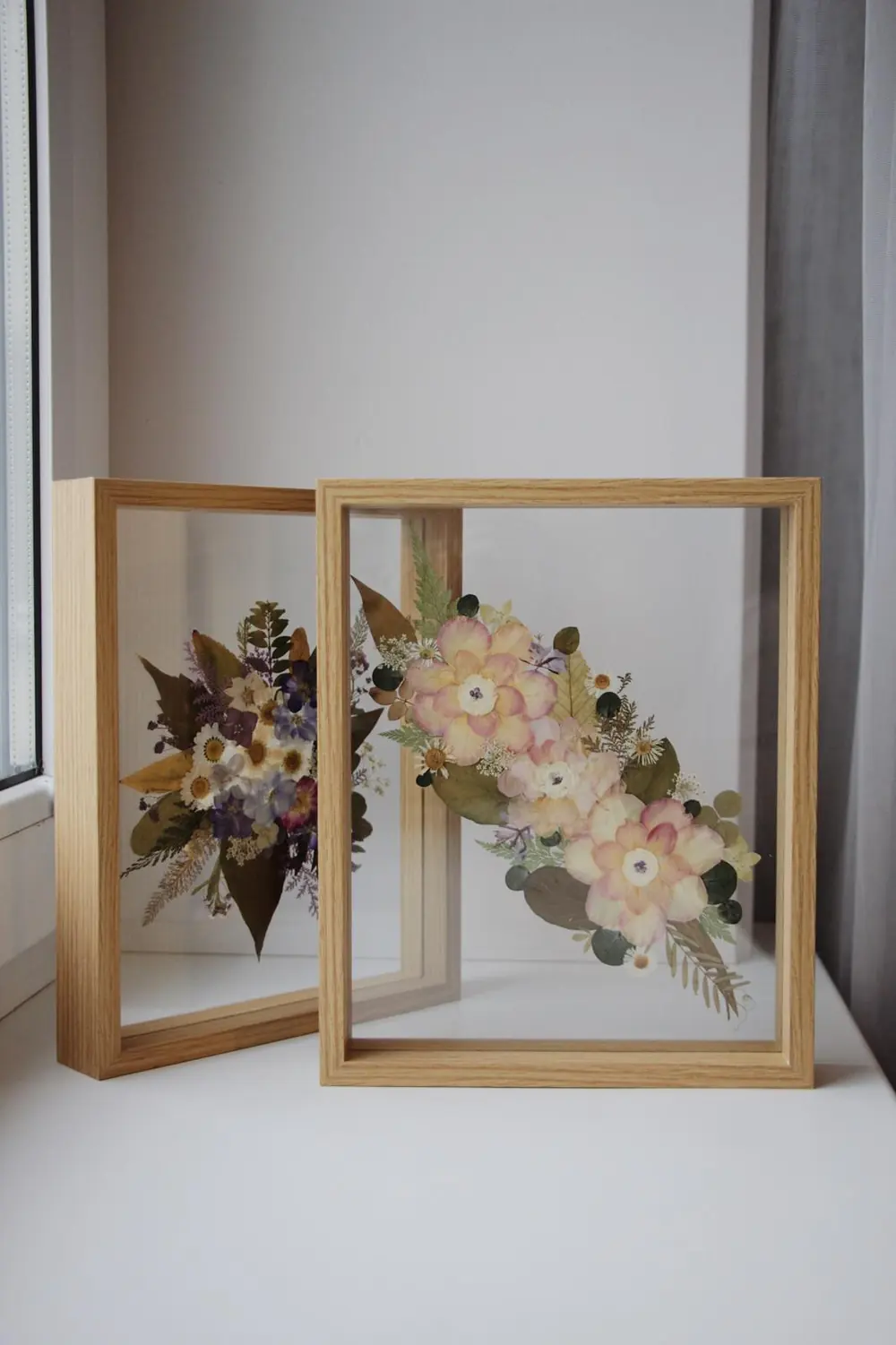 Two pressed flower frames in double glass on a windowsill